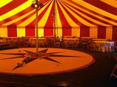 a large circus tent with tables and chairs