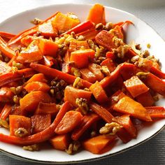 a white plate topped with carrots and nuts