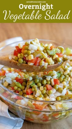 a wooden spoon filled with vegetables on top of a bowl