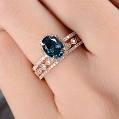 a woman's hand with a ring on it and a blue stone in the middle