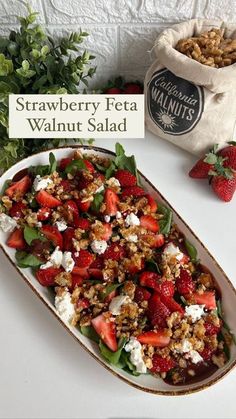 strawberry feta walnut salad on a platter next to a bag of granola