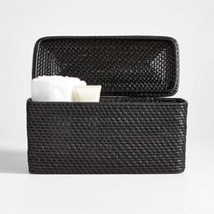 two black baskets with white towels in them