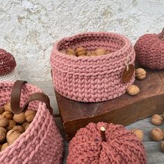 two knitted baskets filled with nuts on top of a wooden box next to other items