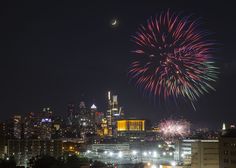 fireworks are lit up in the night sky over a city skyline with buildings and skyscrapers