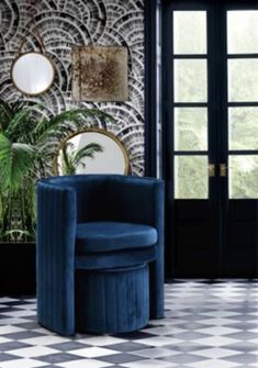 a blue chair sitting in front of a wall with mirrors on it's sides