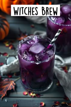 two glasses filled with purple liquid and ice on top of a table next to pumpkins