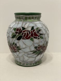 a mosaic vase with roses and leaves on it