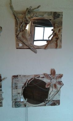 there are two mirrors on the wall and one is made out of driftwood pieces