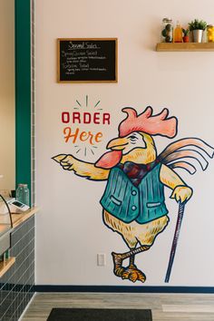 there is a mural on the wall of this restaurant that depicts a chicken with a hat, vest and cane