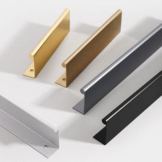 four different types of door handles on a white surface with gold, silver, and black