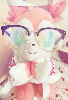 a pink and white stuffed animal wearing glasses