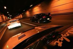 two cars driving down the road at night