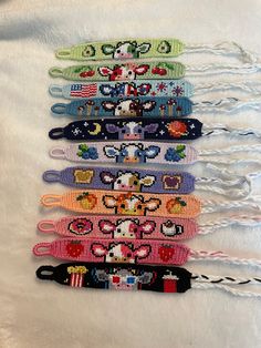 six different colored bracelets are lined up on a white surface