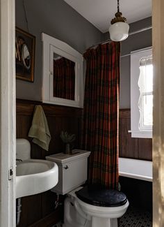 a bathroom with a sink, toilet and bathtub next to a window in it