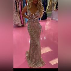 a woman is standing in a store wearing a dress with sequins on it