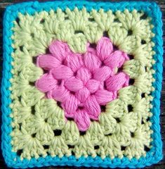 a crocheted square with a pink heart on it