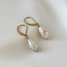 "Introducing Baroque Pearl Earrings in a mesmerizing combination of gold and fresh water pearls. These dangle drop earrings are perfect for the modern woman who loves a touch of elegance in her minimalist style. The beautiful Baroque pearls gracefully dangle from the gold hooks, creating a chic and timeless accessory. Ideal for anniversary celebrations, weddings, or any special occasion, these earrings will make a stunning statement. Give the gift of refined beauty with these Baroque Pearl Minim 14k Gold Filled Pearl Drop Earrings For Anniversary, 14k Gold Filled Pearl White Dangle Pearl Earrings, Dainty Pearl White 14k Gold Filled Pearl Earrings, 14k Gold-filled Pear-shaped Pearl Drop Jewelry, 14k Gold-filled Pearl White Earrings With Pearl Charm, Pearl White Earrings With Pearl Charm In 14k Gold, Elegant Drop Pearl Earrings In 14k Gold Filled, Elegant 14k Gold-filled Earrings With Pearl Charm, Elegant 14k Gold Filled Earrings With Pearl Charm