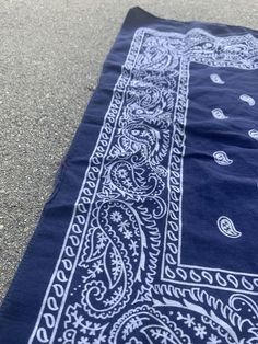 a blue and white bandana laying on top of the ground next to a sidewalk