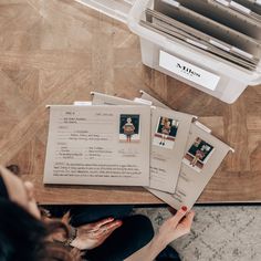 a person sitting at a table with some papers on top of it and an air conditioner in the background