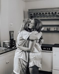 two women hugging each other in the kitchen