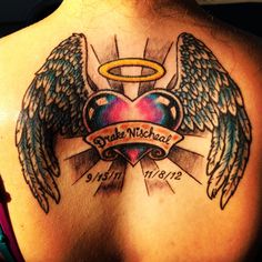 the back of a woman's chest with angel wings and a heart on it