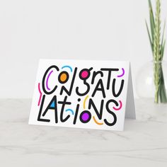 a card with the words constatuations on it next to some flowers