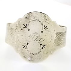 "Description: An antique silver cuff bracelet with embossed and hand engraved embellishments. The front has and engraved monogram NYL. Unmarked but tested to be at least coin silver which is 900 silver. The opening is flexible and easy to put on and remove. The shape can be adjusted for any size wrist by your local jeweler for a final fit. Circa 1850's - 1870's. Weighs 15.2 grams. Measurements: The inside diameter measures 2\" at the widest and fits on a average sized wrist. Condition: Good with