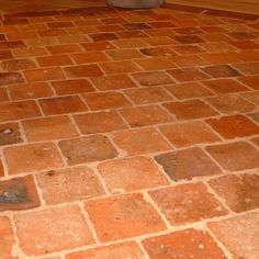 a toilet sitting on top of a brick floor