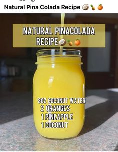 a jar filled with orange juice sitting on top of a counter next to a sign that says natural pinacolada recipe