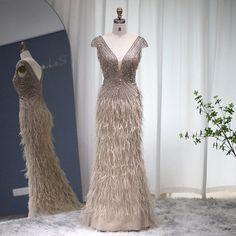 two mannequins dressed in long, feathery dresses