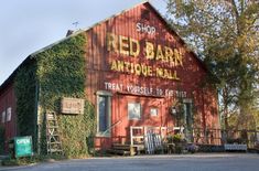 an old red barn with the words red barn antique mall painted on it