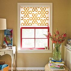 a vase with flowers sitting next to a window in a room that has yellow walls