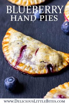 blueberry hand pies on a slate surface with fresh blueberries in the background