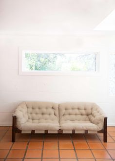 a white couch sitting on top of a tiled floor