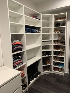 an organized closet with white shelving and lots of shoes