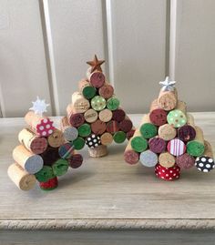 three wine cork christmas trees sitting on top of a table