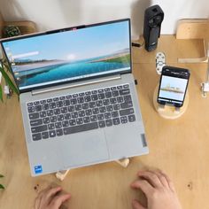 a person sitting at a table with a laptop and cell phone in front of them