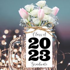 a mason jar filled with white flowers and the words class of 203 graduate on it