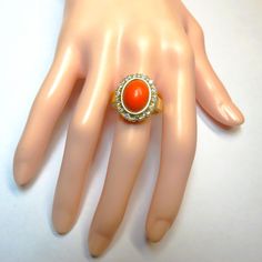 Italian Red Coral White Diamond 14k Yellow Gold Ring featuring a 3 carat Italian Red Coral Cabachon surrounded by half a carat of sparkling White Diamonds. Ring size: 7.  All photo's taken in daylight so you can see the color of the coral which is very dense and even in color. The ring measures 18mm long x 15 mm wide.   The oval carved red coral gem is 12 mm x 8 mm.   Each 2mm diameter white diamond is class G-H VS2-SI. Hallmarked 14k inside the band. Weight: 8 grams.  Ring ships fully insured with signature on delivery and gift wrapped. Oval Diamond Ring For Collectible, Red Diamond Oval Cabochon Ring, Oval Diamond Ring For Collectors, Victorian Oval Red Diamond Ring, Victorian Style Red Oval Diamond Ring, Red Oval Diamond Ring With Accents, Antique Oval Red Diamond Ring, Antique Red Oval Diamond Ring, Oval Red Diamond Ring With Accents