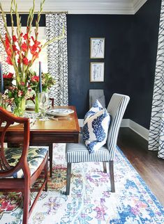 a dining room with blue walls and floral decor