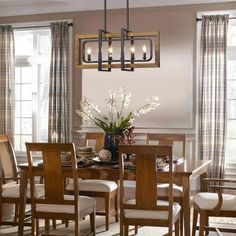 a dining room table with chairs and a vase filled with flowers on top of it