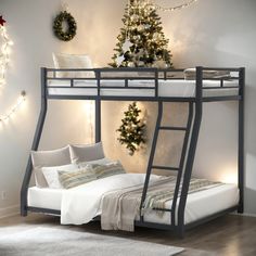 a bunk bed with a mattress underneath it next to a christmas tree