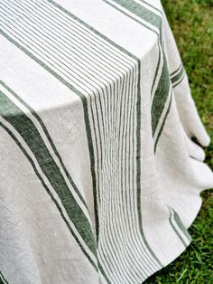 an image of a white and green table cloth on the ground with grass in the background