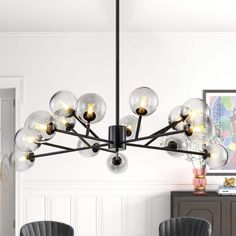 a modern chandelier with glass balls hanging from it's centerpiece in a dining room