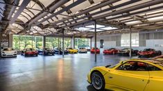 a large garage filled with lots of different colored sports cars in it's center