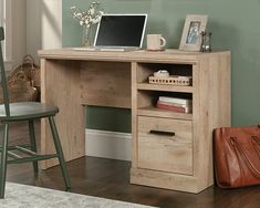 a wooden desk with a laptop on top of it next to a chair and purse