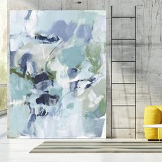 an abstract painting is hanging on the wall next to a yellow chair in a white room