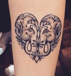 an elephant heart tattoo on the right thigh and calf's leg, with two elephants in the middle