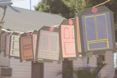 a line of clothes hanging from the side of a house with windows and doors painted on them