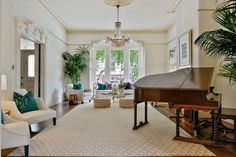 a living room filled with furniture and a grand piano